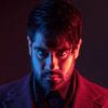 Dhawan Master face on half lit in red, half in blue.