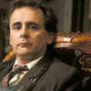 The Seventh Doctor.  Brown Coat, head and shoulders, seated in an ornate chair.