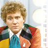 The Sixth Doctor in the Tardis looking puzzled