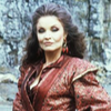 Kate O'Mara as the Rani.  Waist up looking at Camera in red.