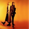 Yellow toned image of Thirteen and Yaz standing back to back
