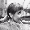 Vicki from Doctor Who hiding behind a rock.