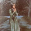 Very damp woman in a long green dress standing in the rain.
