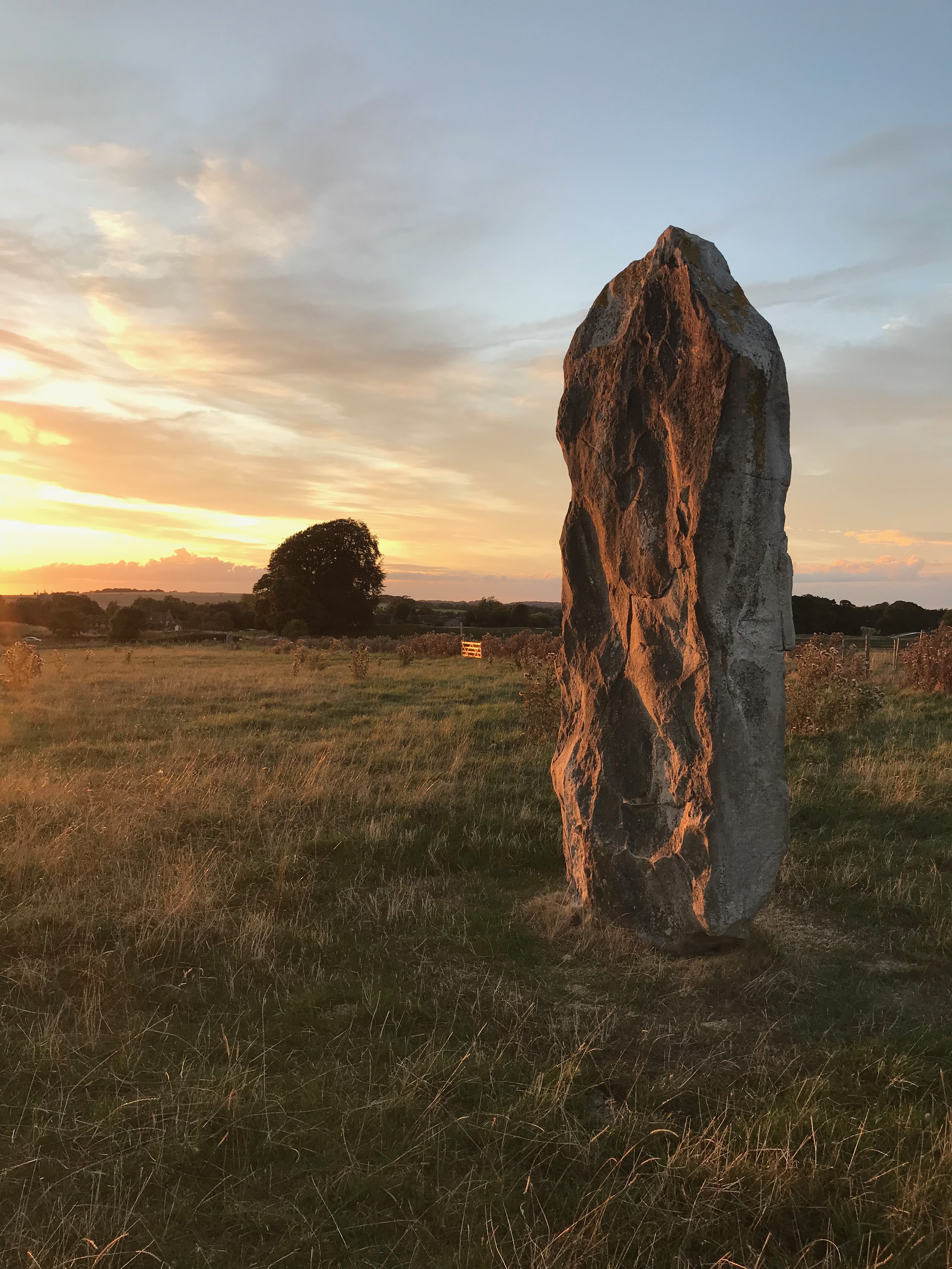 A lone standing stone against the sunset.