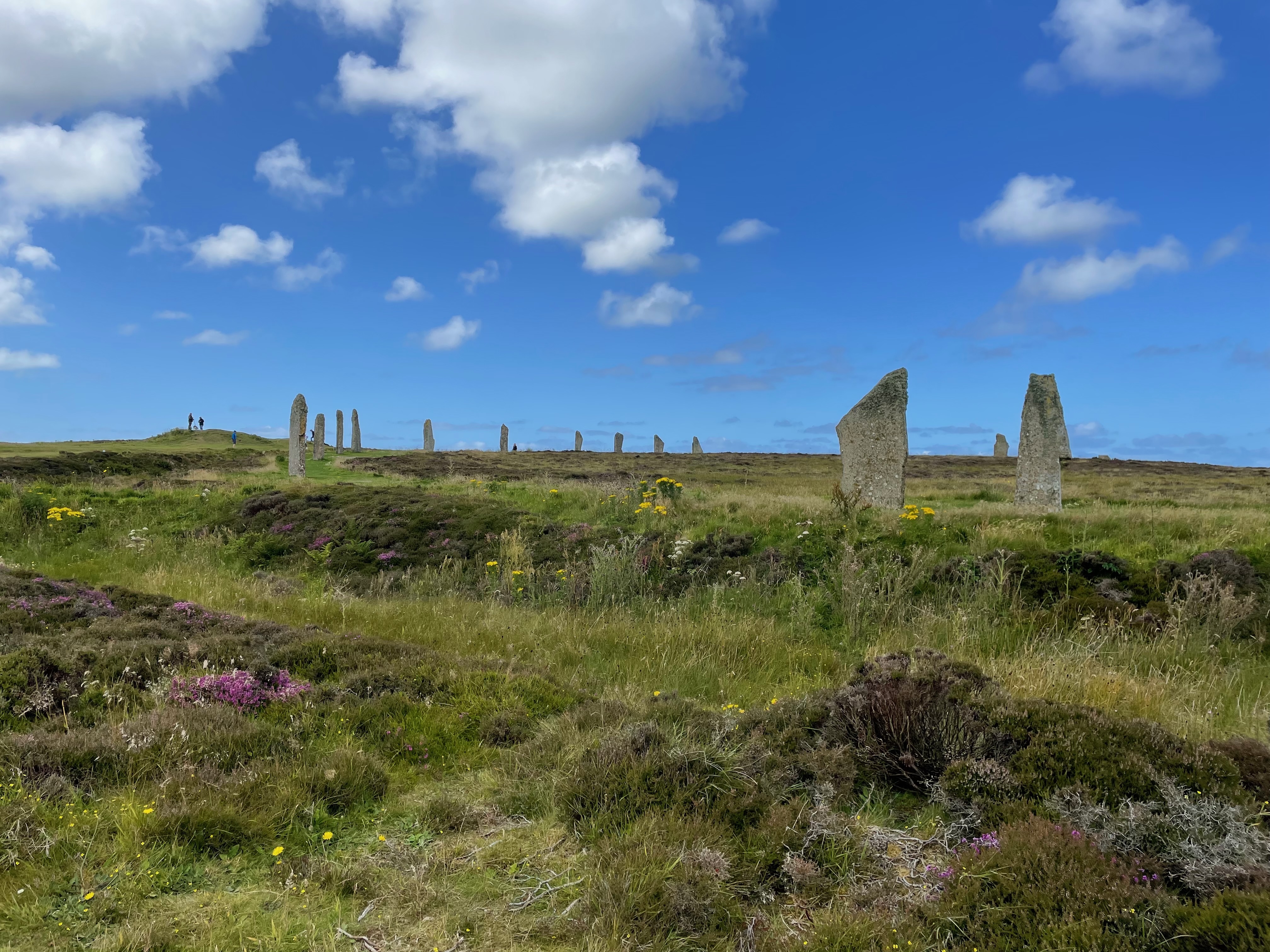 A large stone circle surrounded by a ditch against a blue sky