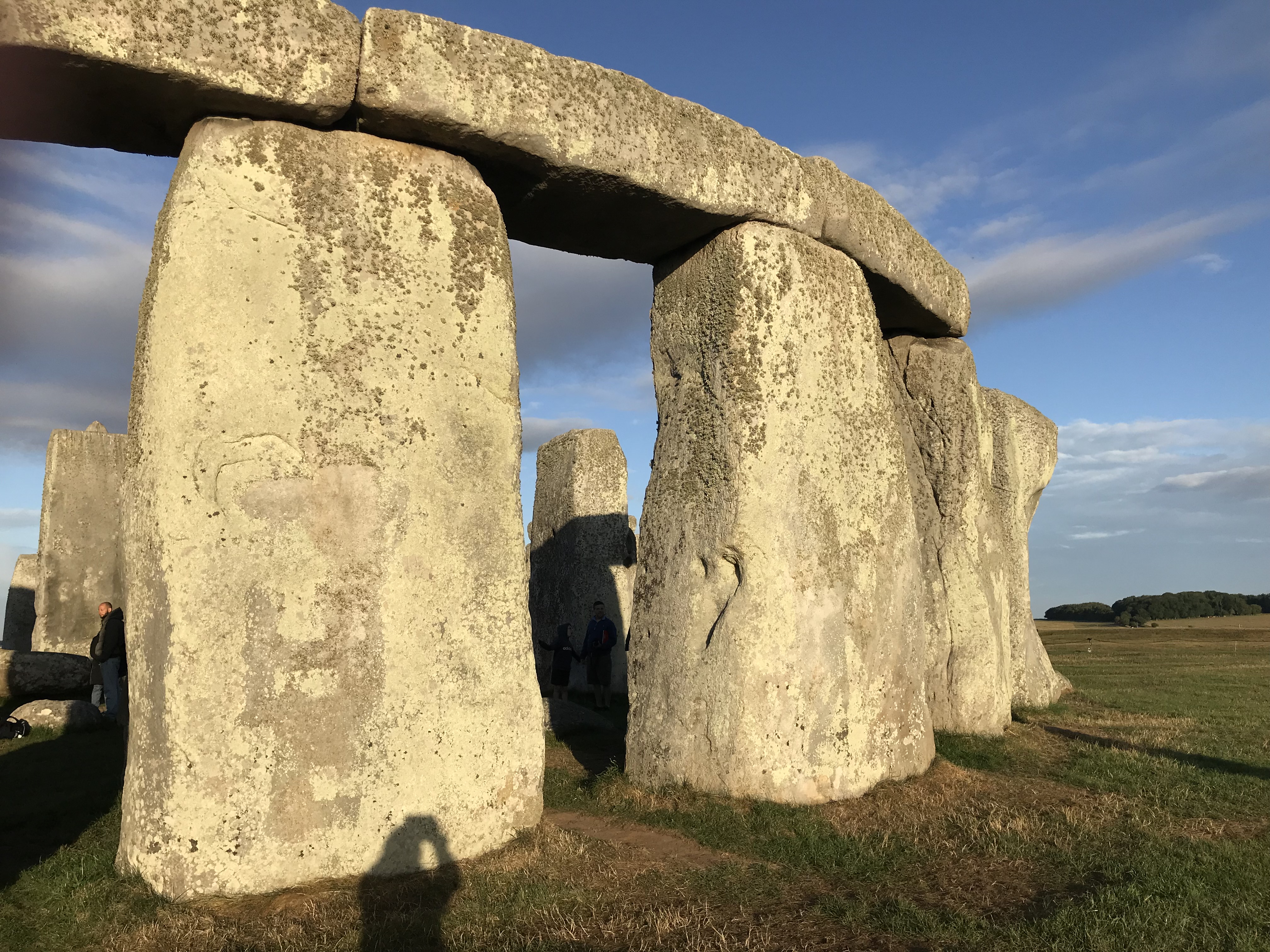 Curve of one of the. rings at Stonehenge where the cross stones are still in place.  Shadow of the photographer visible.