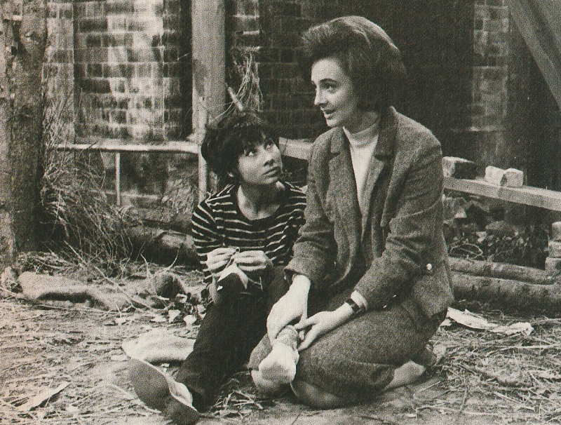 Image from Dalek Invasion of Earth. Barbara is kneeling with Susan sitting next to her. Barbara is holding Susan's ankle while Susan is holding her shoe and looking at Barbara.