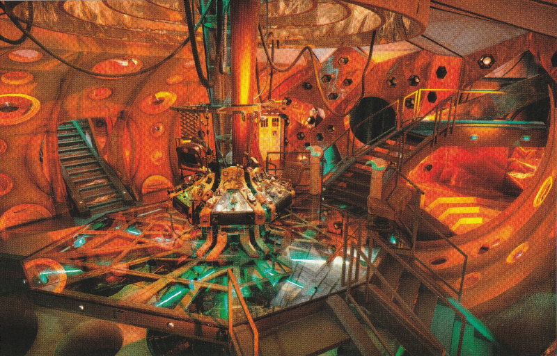 Interior of the Tardis based in orange list with some green highlights.  View from above looking down on raised console area, staircases lead down to it from holes in the walls, and steps led down from it to the floor below.  You can see through the glass panels in the consoler area floor.