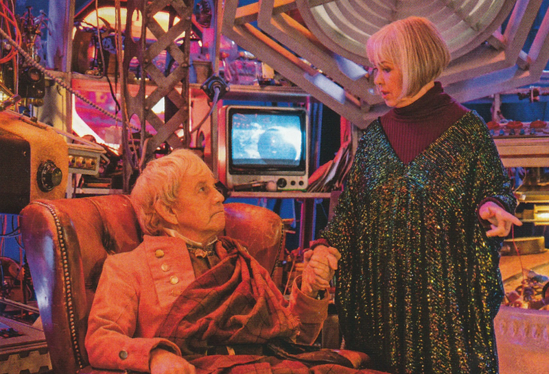 An older Jamie and Zoe from Tales of the Tardis.  They are in the memory Tardis.  Jamie is seated in a chair and Zoe stands next to him holding his hand.